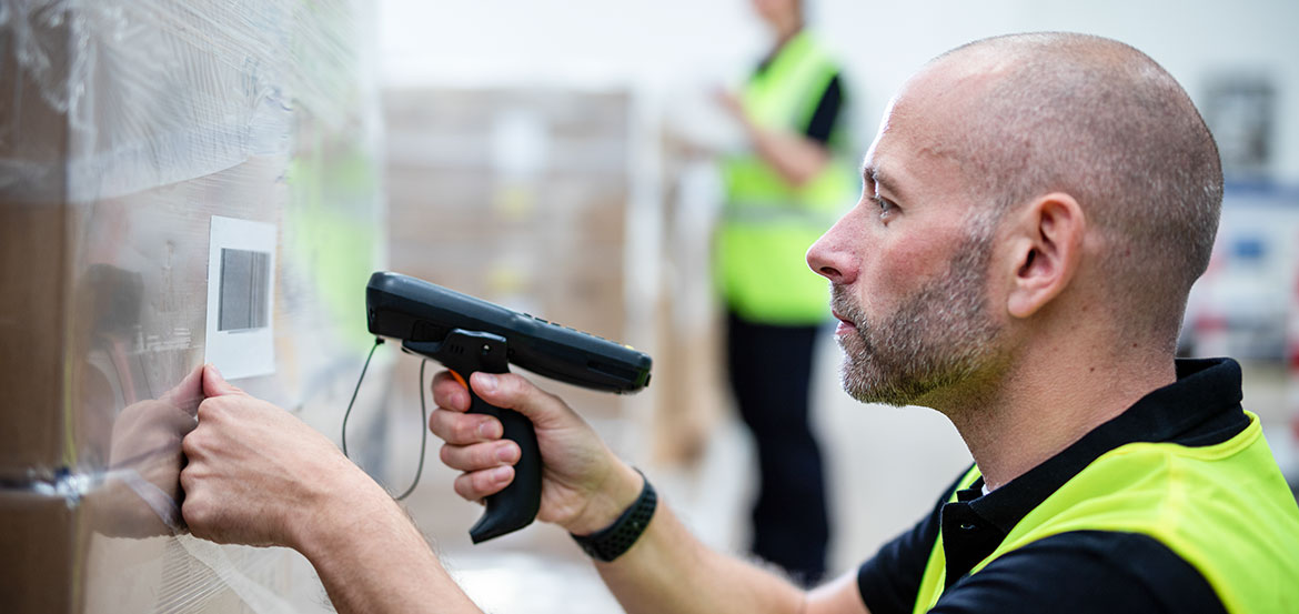 Man in high visibility vest scanning barcode label 